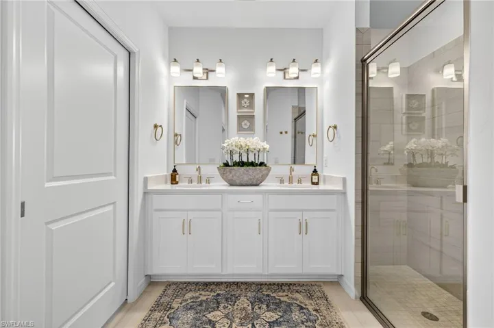 Full bathroom with a shower stall and double vanity