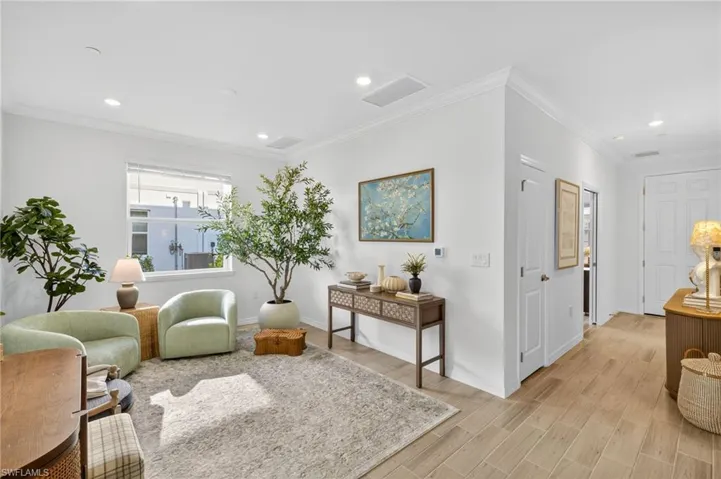 Sitting room with crown molding, wood tiled floors, and recessed lighting