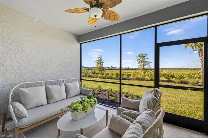 Sunroom with a textured wall, a rural view, and carpet flooring