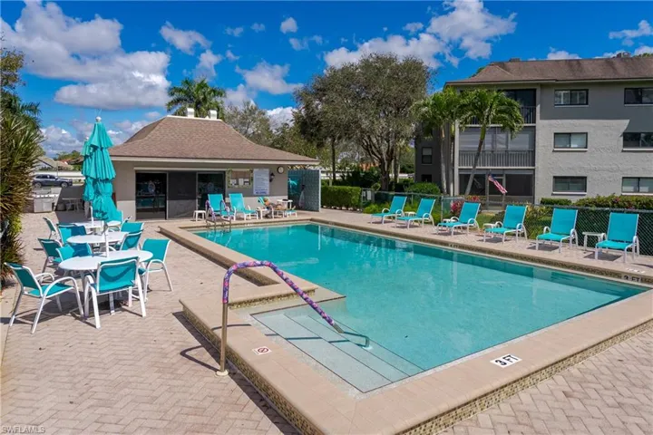 Community pool featuring a patio area and fence