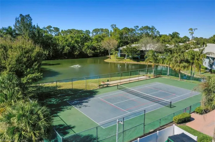 View of tennis court featuring a water view
