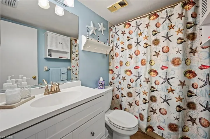 Bathroom featuring vanity, toilet, and walk in shower