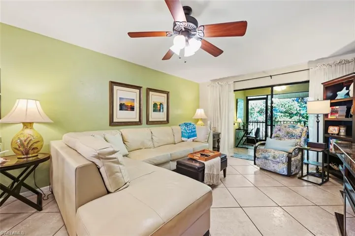 Living room with ceiling fan and light tile patterned floors