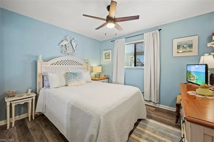 Bedroom with dark hardwood / wood-style floors and ceiling fan