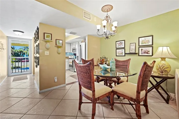 Dining space with light tile patterned flooring and a chandelier
