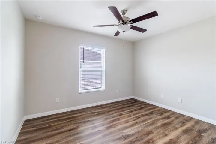Garage featuring electric water heater, electric panel, and a garage door opener