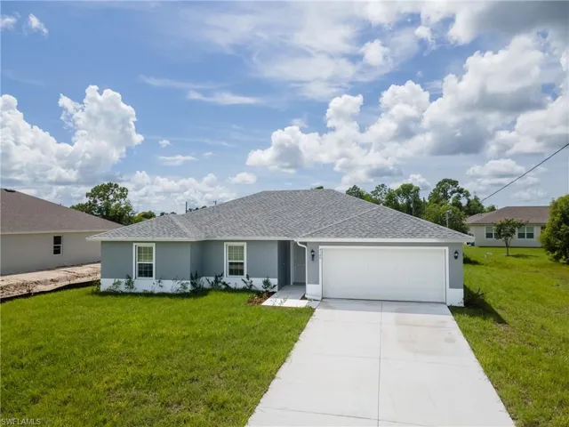 Single story home with a front lawn, stucco siding, roof with shingles, and driveway
