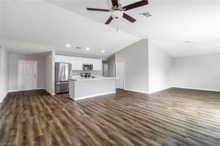 Unfurnished room with dark wood-style flooring and a ceiling fan