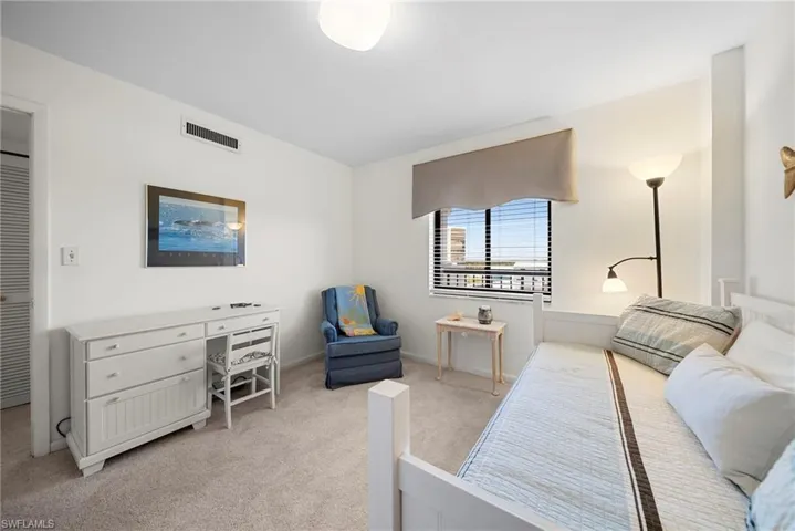 Bedroom with light colored carpet and baseboards