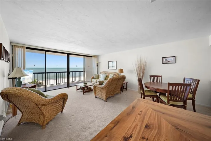 Carpeted living area featuring a wall of windows and a textured ceiling