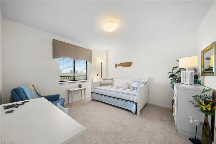 Bedroom featuring light carpet and baseboards