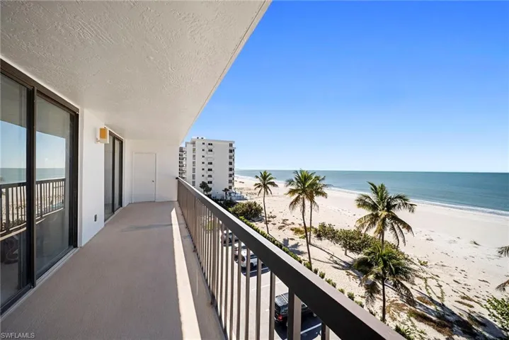 Balcony featuring view of water and beach