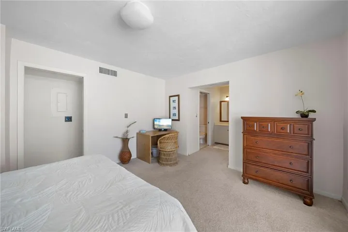 Bedroom featuring light carpet and connected bathroom