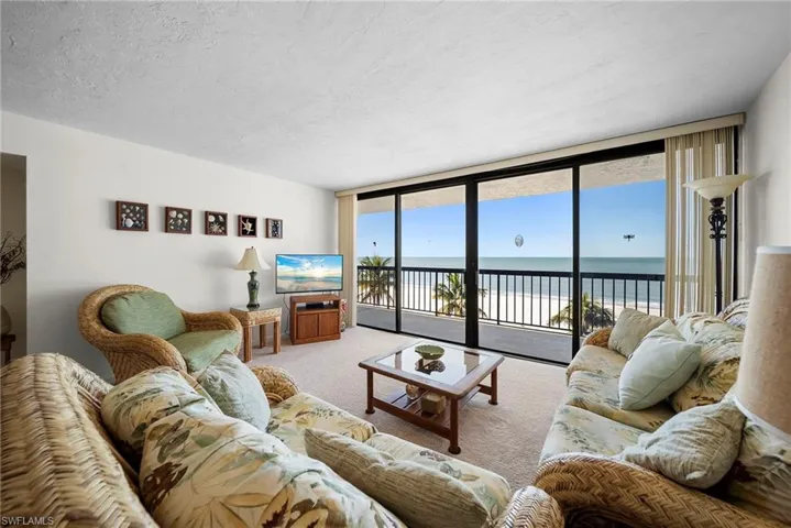 Carpeted living room with expansive windows and a textured ceiling