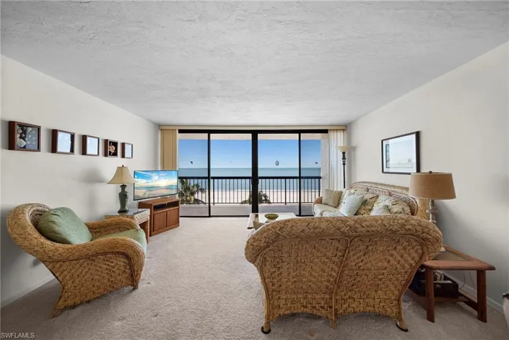 Carpeted living area featuring expansive windows and a textured ceiling