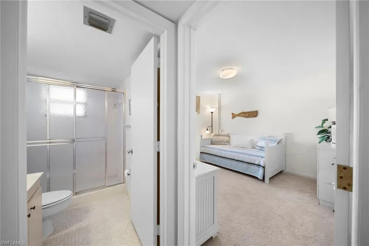 Bathroom featuring vanity, ensuite bathroom, a shower stall, and light carpet
