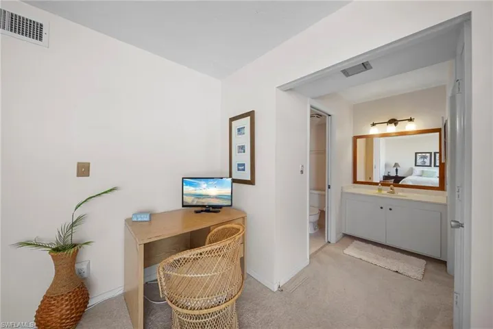 Office area featuring light colored carpet and baseboards