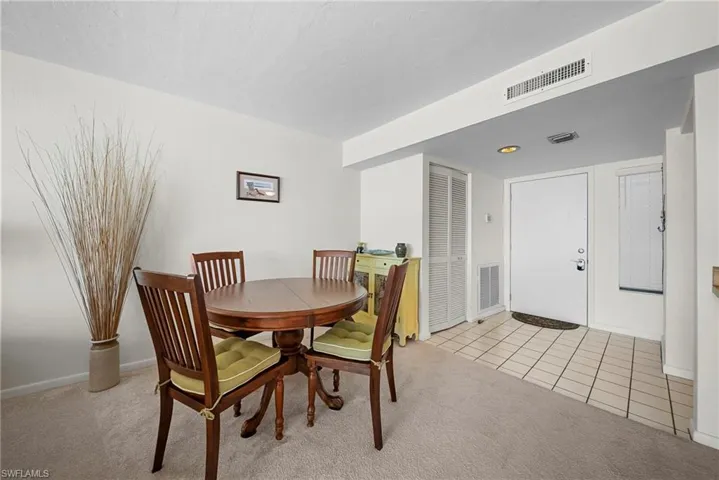 Dining room with light carpet and light tile patterned floors