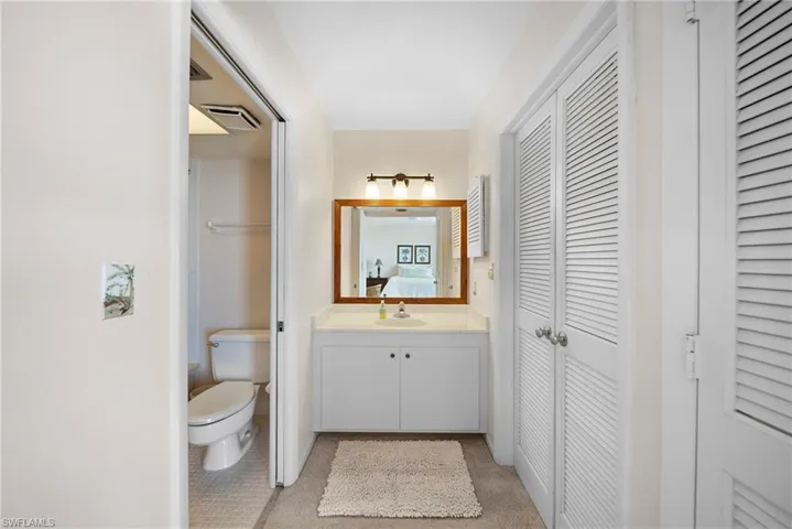 Ensuite bathroom featuring a closet and vanity