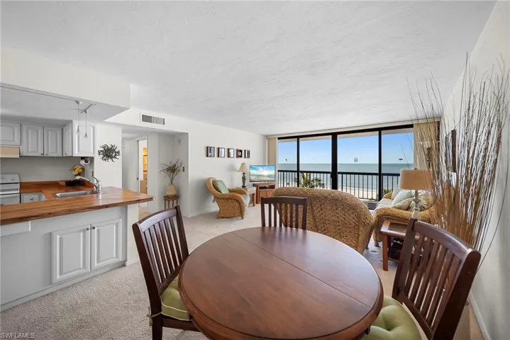 Dining area with light carpet and a wall of windows