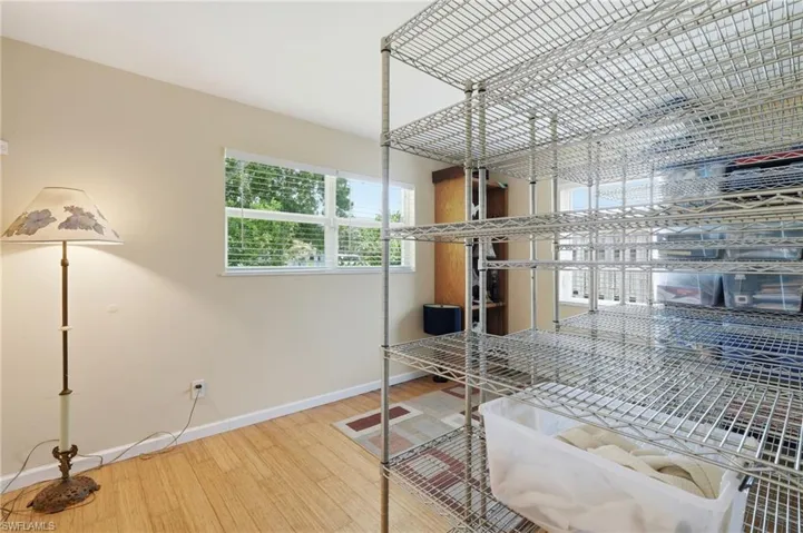 Room featuring wood-finish flooring and a multi-panel window with horizontal blinds