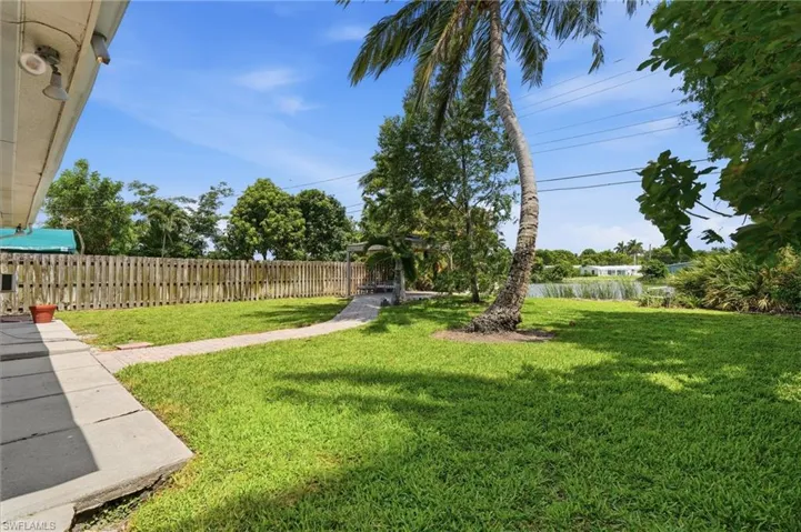 Expansive green lawn with mature palm tree