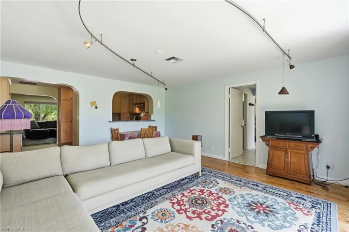 Open-concept living area featuring wood-finish flooring and track lighting