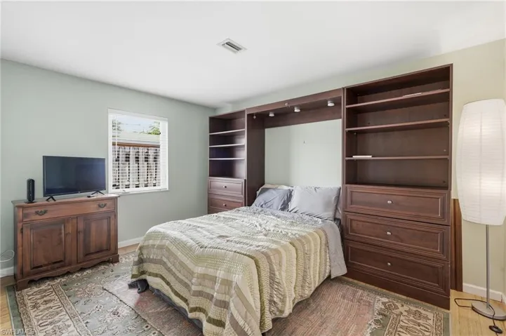 Built-in wall unit featuring recessed lighting, integrated shelving, and drawer storage