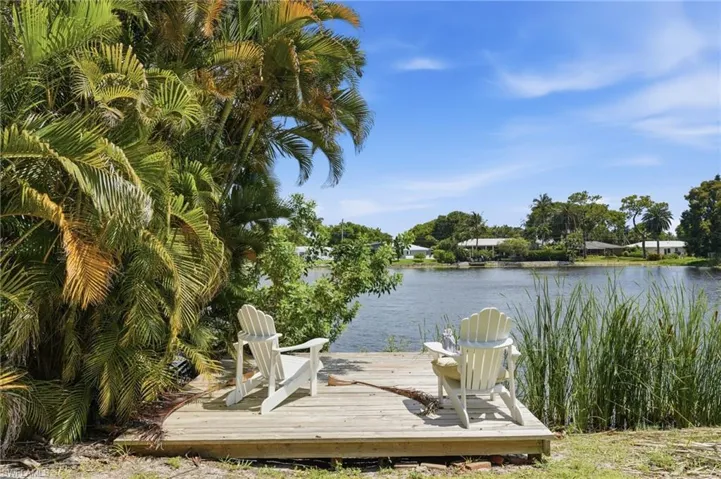 Waterfront wood-finish decking, surrounded by lush palm foliage and natural reeds