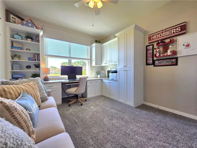 Office featuring built in study area, carpet, and a ceiling fan