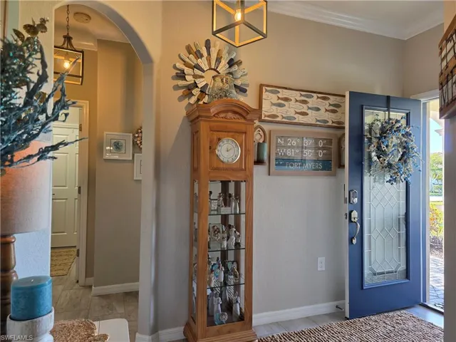 Foyer featuring arched walkways and ornamental molding