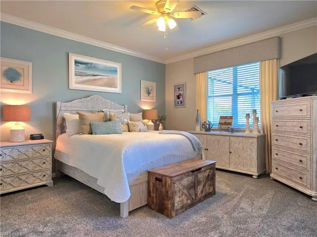 Bedroom with crown molding, carpet, and a ceiling fan