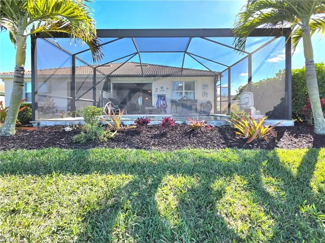 Rear view of house with a lanai and a sunroom