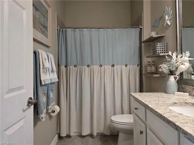 Bathroom with a shower with curtain and vanity