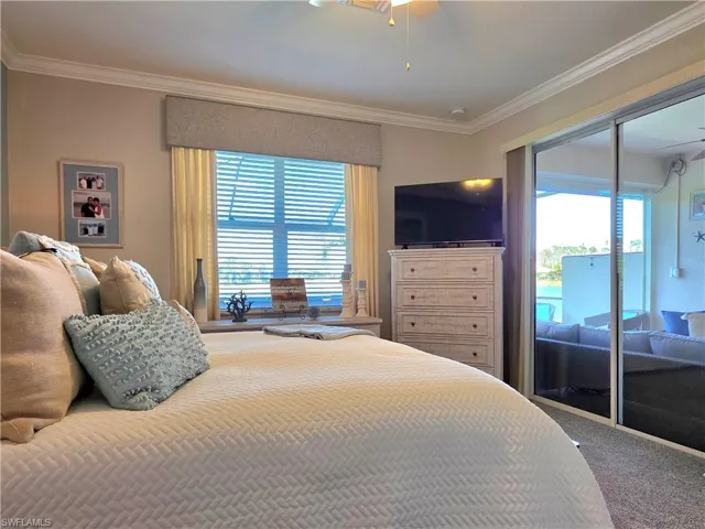 Carpeted bedroom with access to exterior and ornamental molding