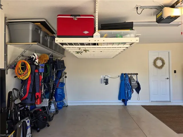 Garage featuring a garage door opener and baseboards