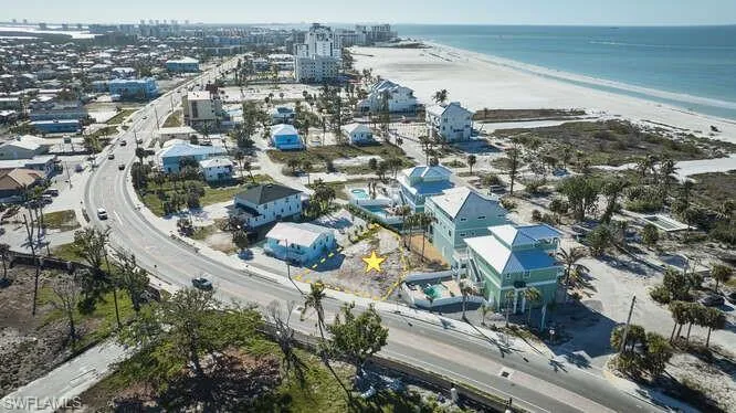 Birds eye view of property with a water view and a view of the beach