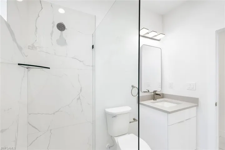 Full bathroom with vanity and a marble finish shower