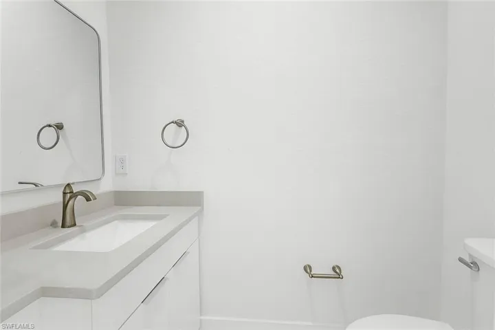 Half bathroom with vanity and toilet