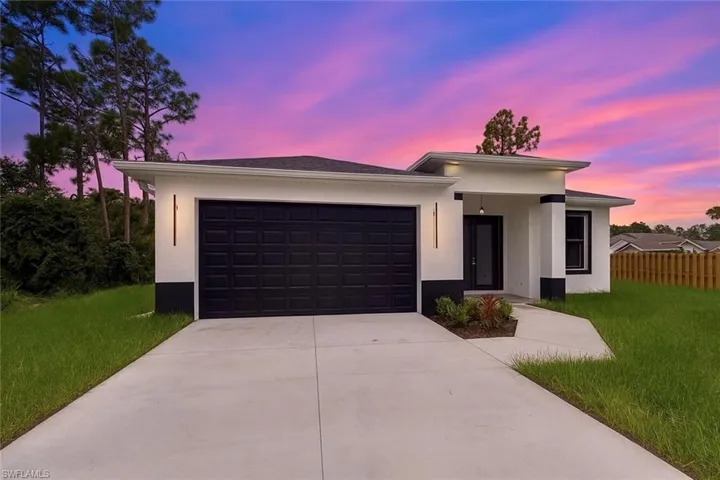 Prairie-style home with stucco siding, driveway, and a garage