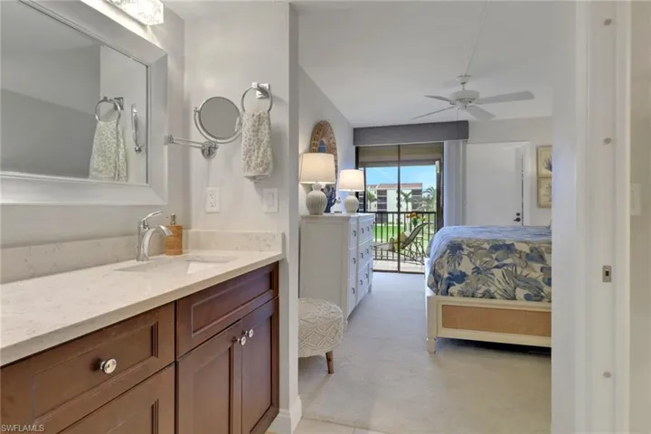 Ensuite bathroom featuring connected bathroom, vanity, and ceiling fan