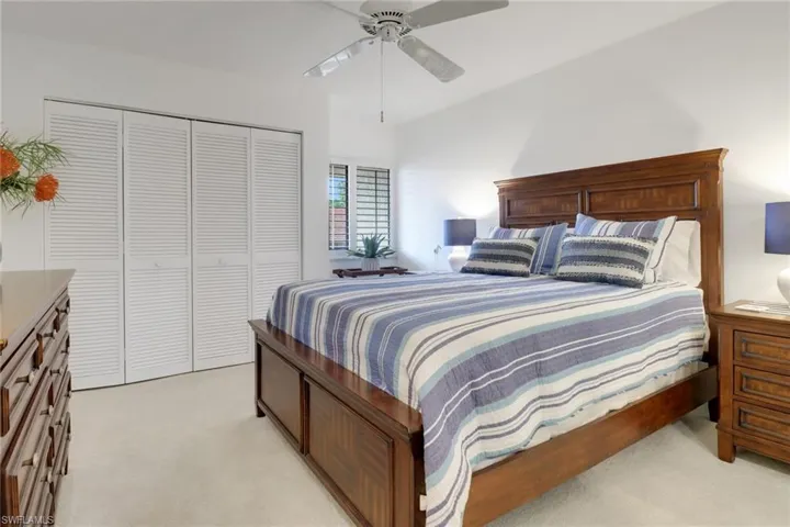 Bedroom featuring a closet, light colored carpet, and ceiling fan