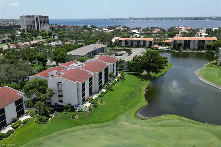 Drone / aerial view with golf course view and a water view