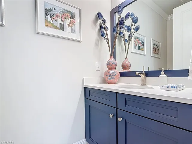 Guest Bathroom featuring vanity with quartz countertop and crown molding