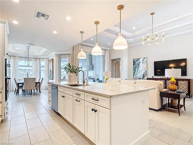Kitchen featuring a raised ceiling,kitchenaid appliances and custom pendant lighting