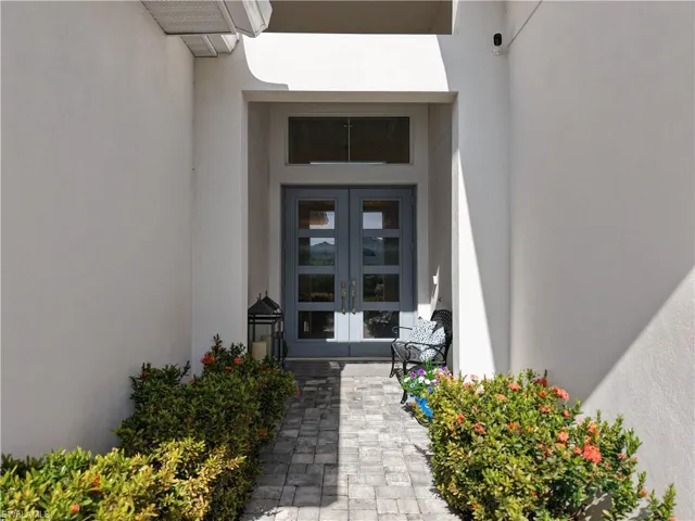 View of exterior entry with stucco siding and french doors