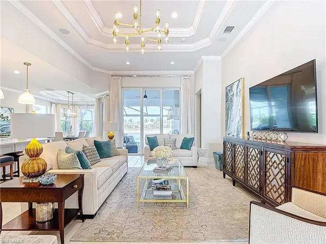 Living room offering beautiful lake views, ceiling speakers, coffered ceiling, crown moldings, designer chandelier, and recessed lighting