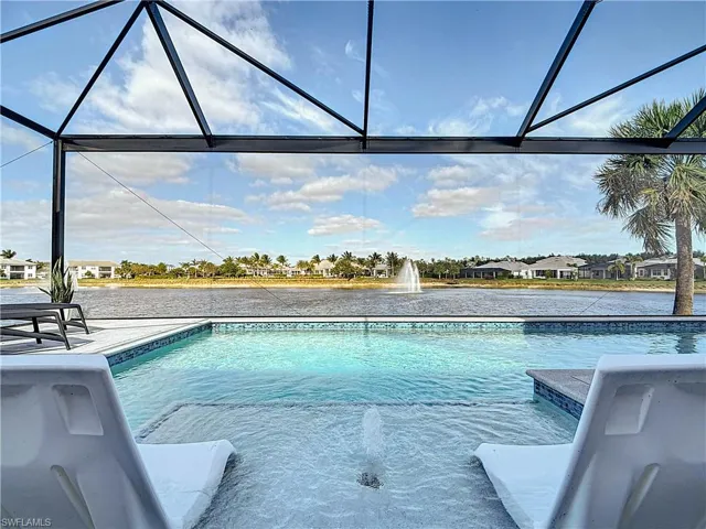 View of salt water heated pool with large screened picture frame window and sunshield with bubbler.