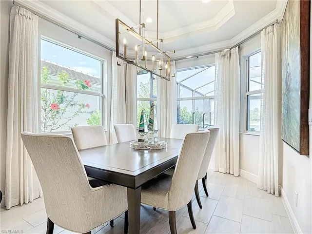 Expanded dining area with custom drapes, coffered ceiling offering scenic lake views