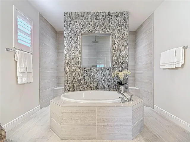 Expanded Master bath featuring twin his and her vanities,  garden tub, walk through custom shower with rainhead and twin shower heads.